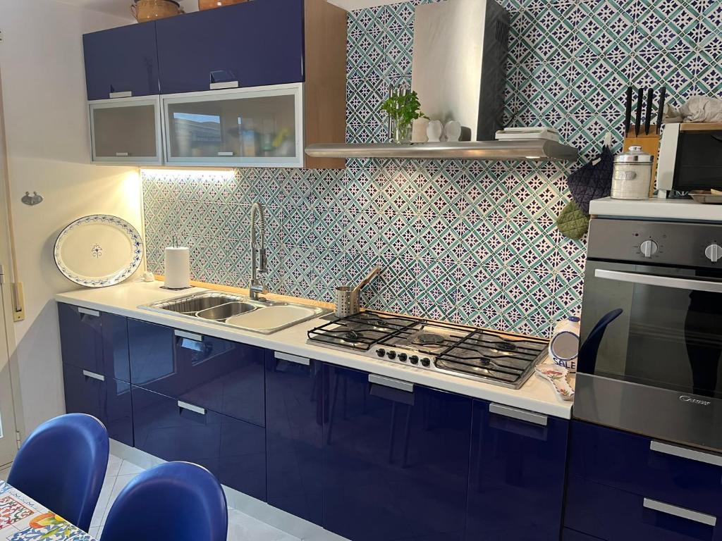 a kitchen with blue cabinets and a stove top oven at Levantea Liv'In Italy in Marsala