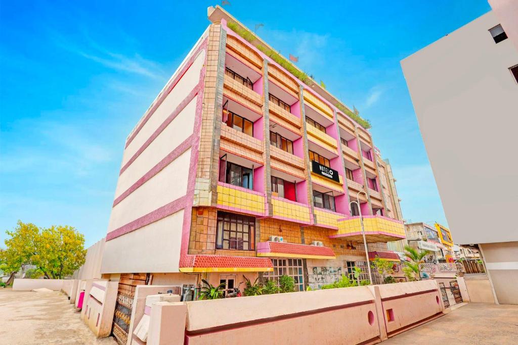 un edificio alto de color rosa y amarillo en Hotel O Gajuwaka, en Visakhapatnam