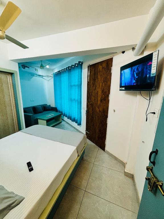 a bedroom with a bed and a tv on a wall at Hotel Minar in Rohtak