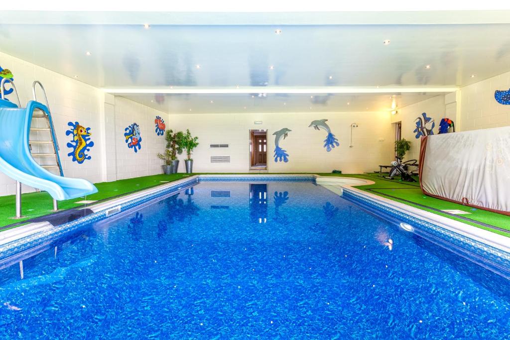 a swimming pool with a slide in a building at Thornbank House in Stranraer