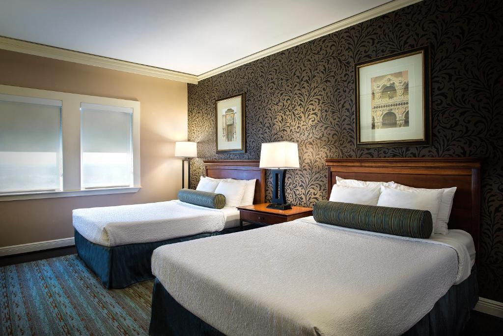 a hotel room with two beds and a window at The Whitehall Houston in Houston