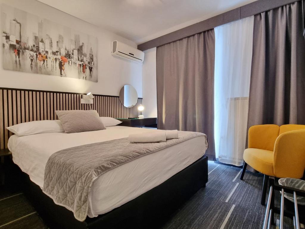 ein Schlafzimmer mit einem großen Bett und zwei gelben Stühlen in der Unterkunft Hotel Bio in Koper