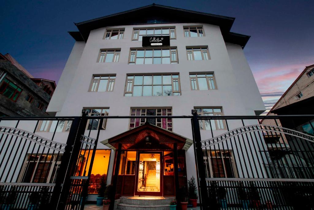 a white building with a door in front of it at Townhouse Oak Rajbagh in Srinagar