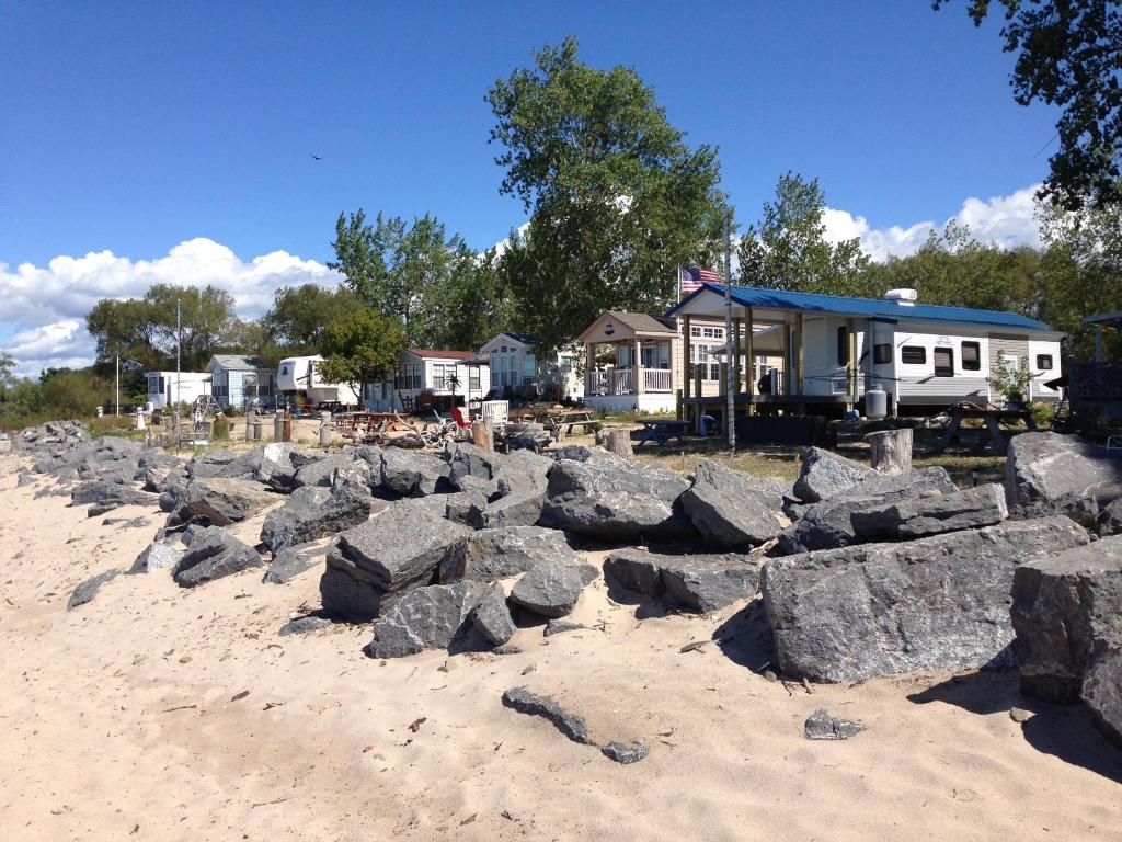 una pila de rocas en la playa al lado de una casa en Brennan Beach Lakeview Loft Park Model 6, en Pulaski