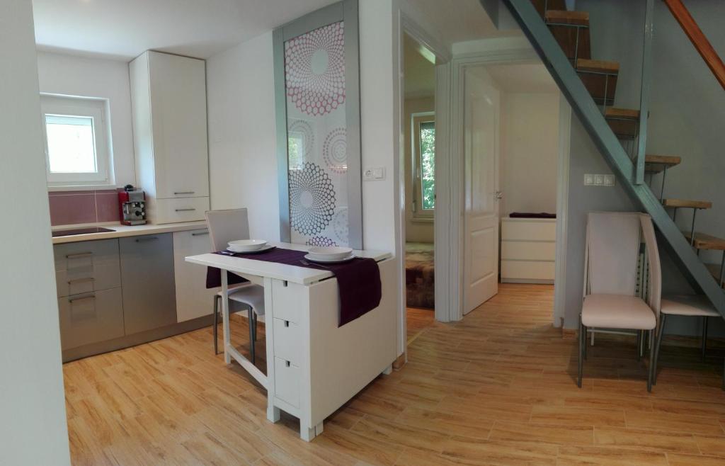 cocina con mesa y escalera en una habitación en Judit Apartman, en Vonyarcvashegy