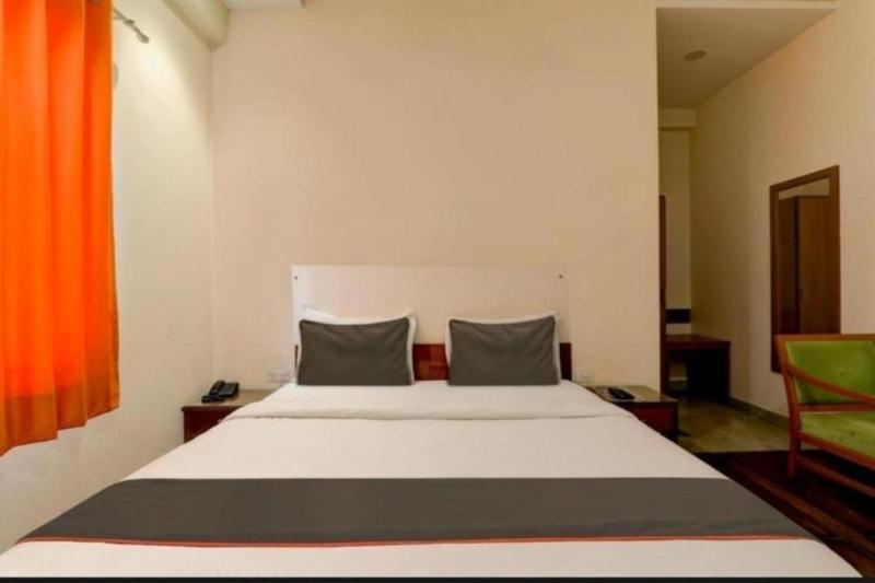 a bedroom with a large white bed with two pillows at RROOMS Hotel Riddhi Inn in Lucknow