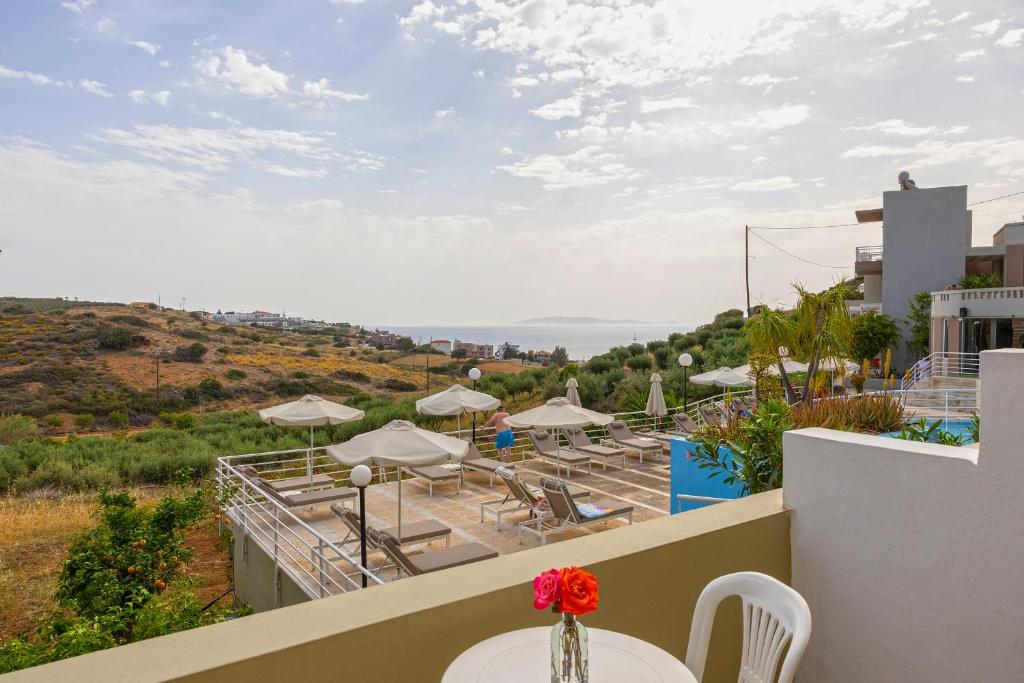 a view of a balcony with tables and umbrellas at Pelagia Bay Hotel in Agia Pelagia