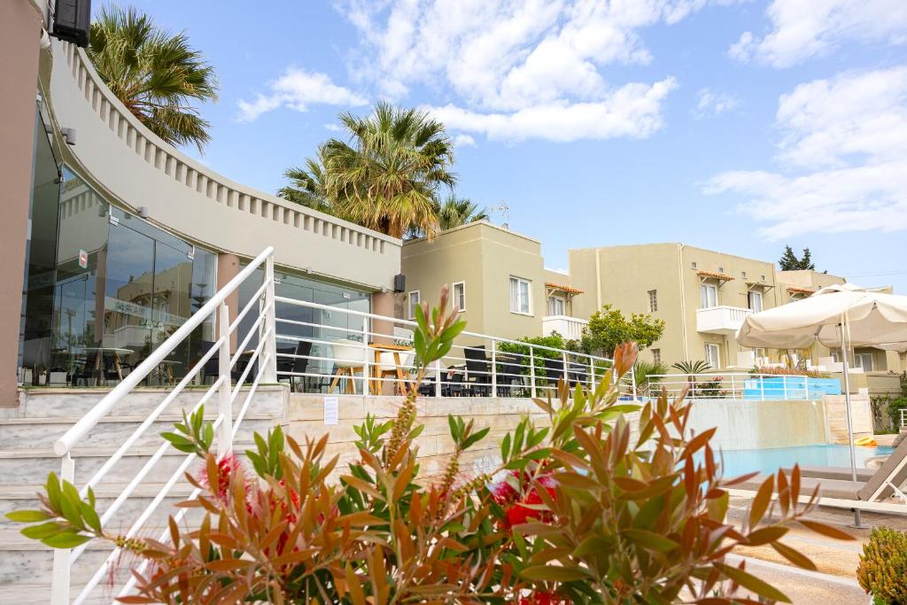 a villa with a swimming pool and palm trees at Pelagia Bay Hotel in Agia Pelagia