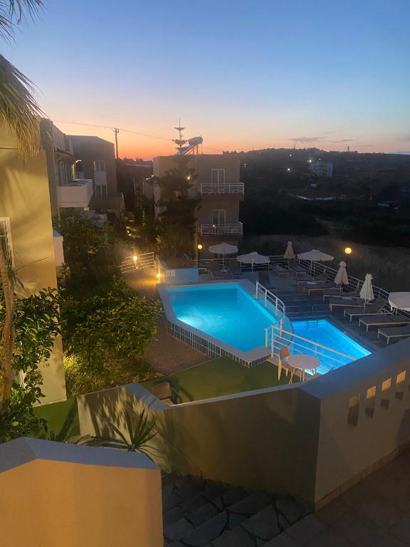 a view of a swimming pool at dusk at Pelagia Bay Hotel in Agia Pelagia