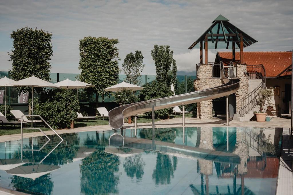 a swimming pool with a slide in a resort at Hotel Berghof - St Johann in Salzburg in Sankt Johann im Pongau