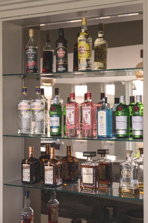 a shelf filled with lots of bottles of alcohol at Pelagia Bay Hotel in Agia Pelagia