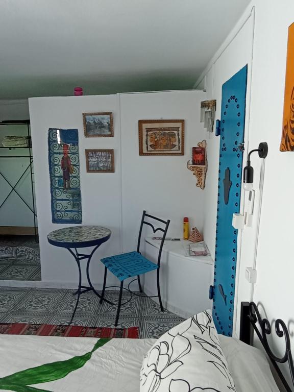 a room with a bed and a table and a chair at Dar Warda in Bizerte
