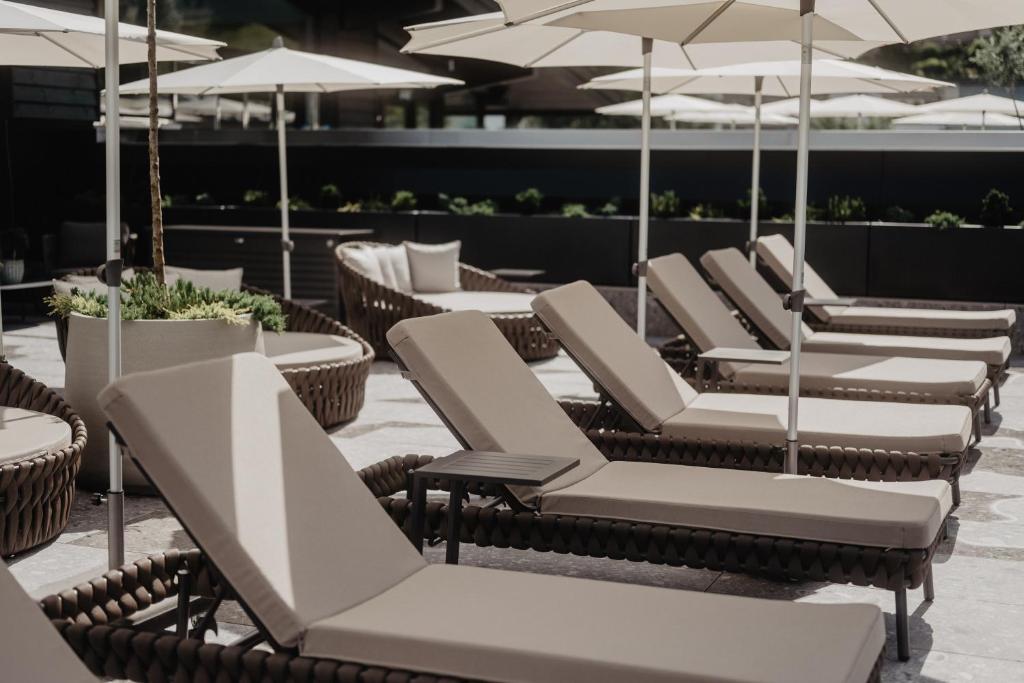 a row of chairs and umbrellas on a patio at Hotel Berghof - St Johann in Salzburg in Sankt Johann im Pongau