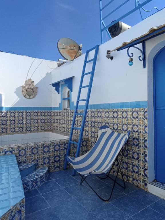 a blue ladder and a chair on a patio at Dar Warda in Bizerte