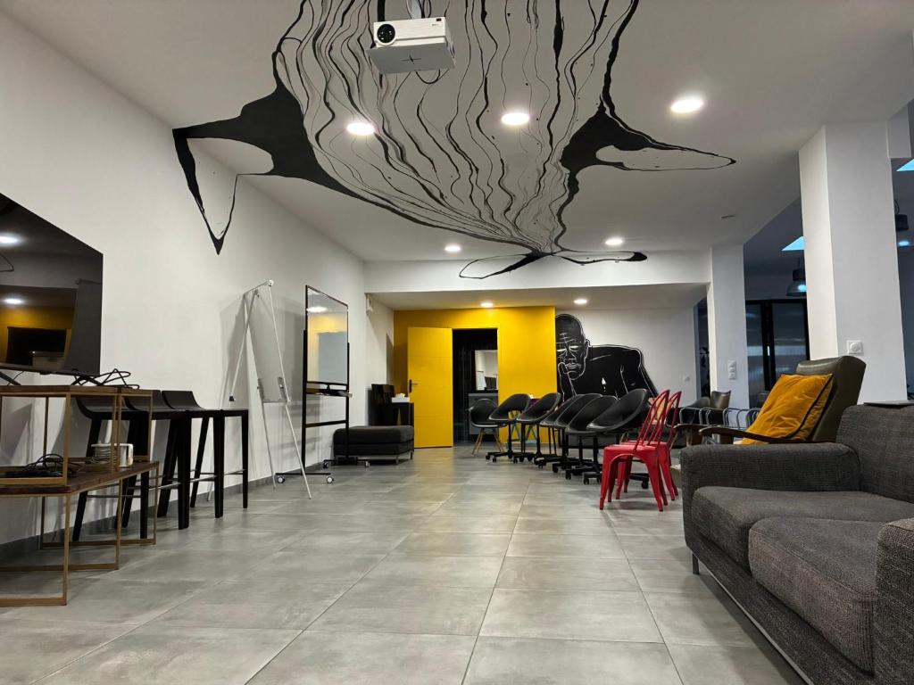 un hall avec des chaises et des tables et un tableau au plafond dans l'établissement Loft de standing Hypercentre Unique à Dunkerque, à Dunkerque