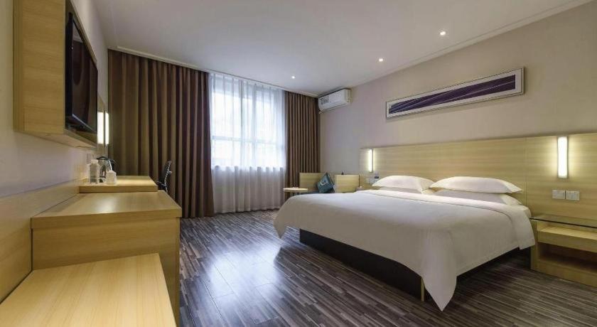 a bedroom with a large white bed and a sink at City Comfort Inn Hotel Guiyang Normal University Yangmingci Metro Station in Guiyang