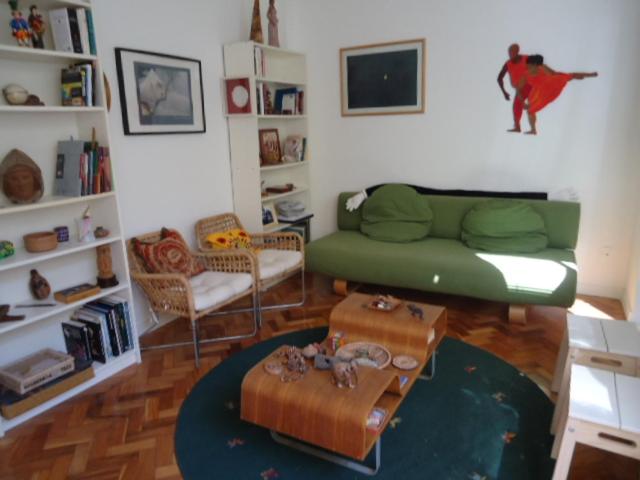 sala de estar con sofá verde y mesa en Ipanema Sensacional, en Río de Janeiro