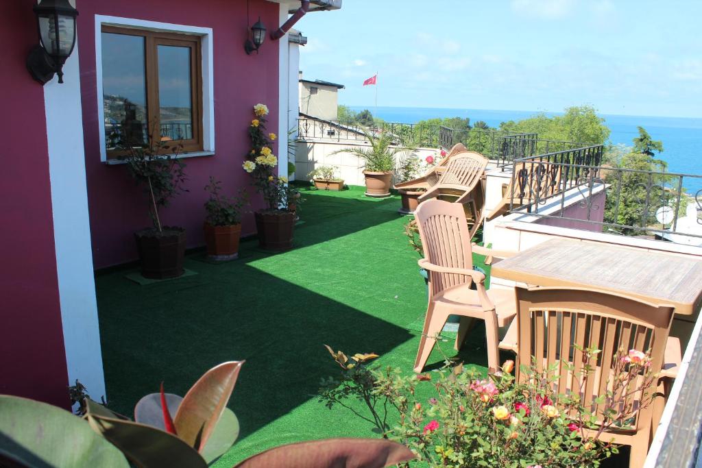a balcony with chairs and plants and the ocean at Nazar Hotel in Trabzon