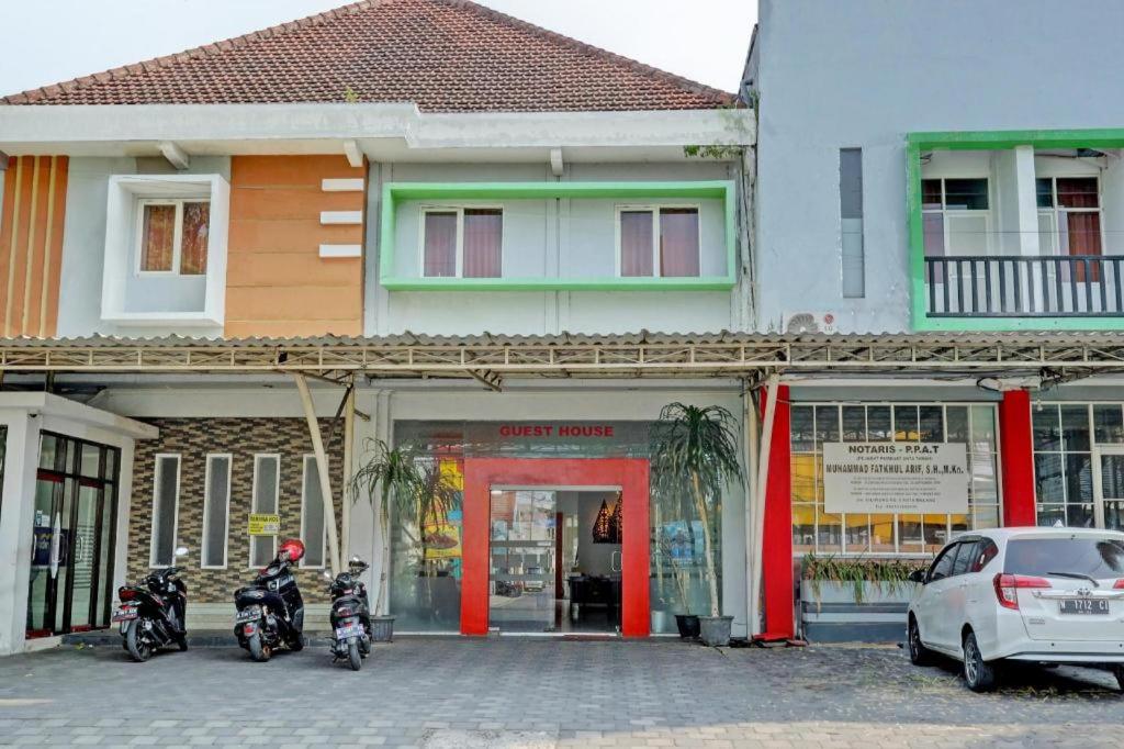 two motorcycles parked in front of a building at Capital O 1362 Ciliwung Guest House Syariah in Malang