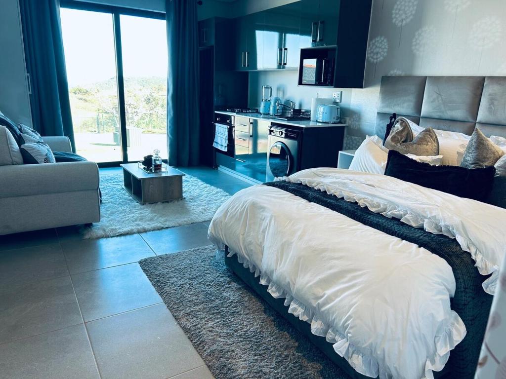 a bedroom with a bed and a living room at Zimbali Lakes Resort Ocean Club D24 in Ballito