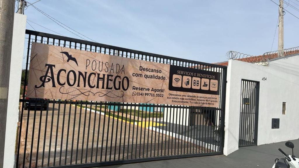 a gate to a building with a sign on it at HOTEL Pousada ACONCHEGO Promissão in Promissão