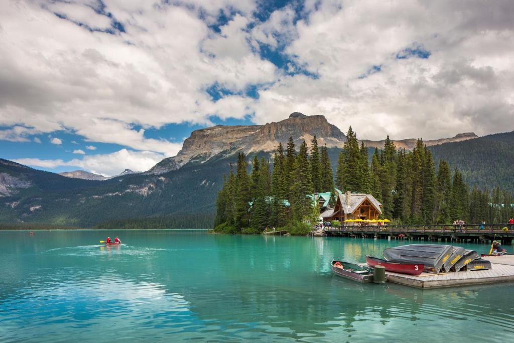 a lake with two boats on a dock in front of a mountain at Emerald Lake Lodge in Field