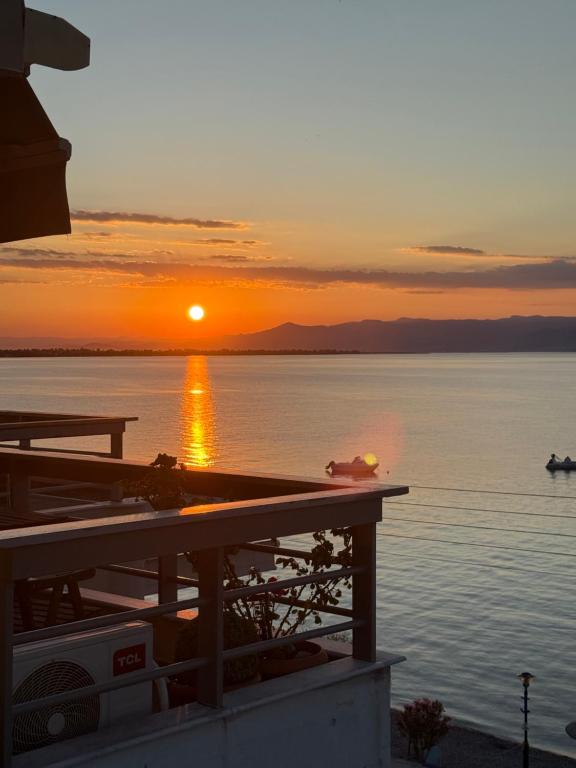 a sunset over the water with a boat in the water at Seacoast apartments 3 ! in Kamena Vourla