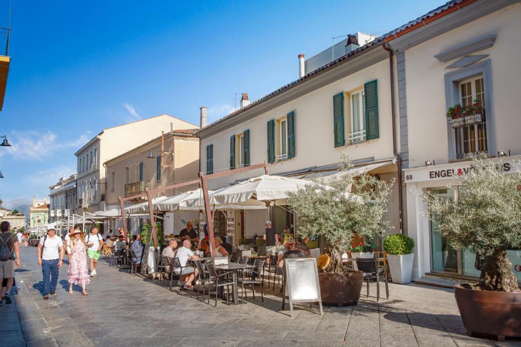 a group of people walking down a street with buildings at Nautilus Suites & Rooms in Olbia
