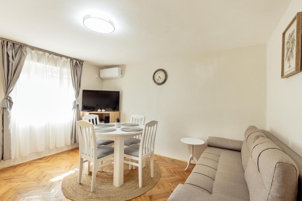 a living room with a couch and a table and chairs at Apartman Kovacevic Hn in Igalo