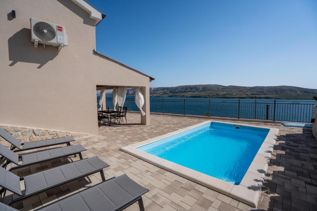 a swimming pool on the patio of a house at Villa Kamia - Luxury seaview villa with private heated pool in Zubovići
