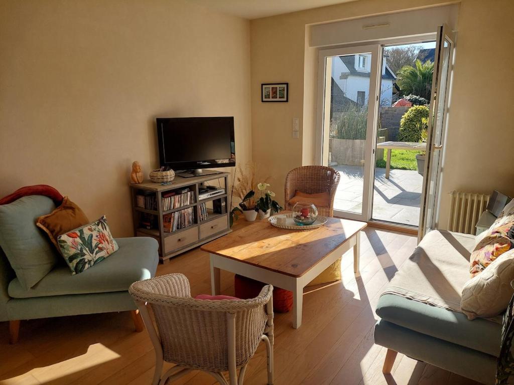 a living room with a tv and a table and chairs at Maison Maurice Quimper in Quimper