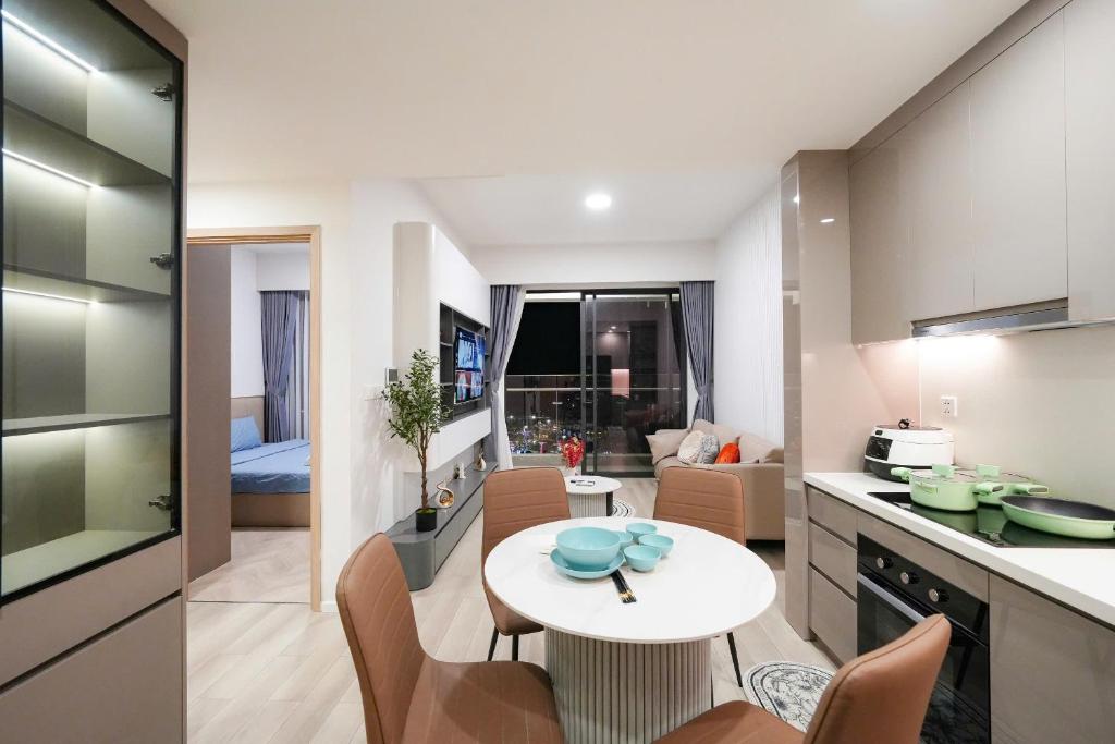 a kitchen and living room with a white table and chairs at Luxury Apartment-Vinhomes Grand Park Quận 9-Plus 2PN in Gò Công