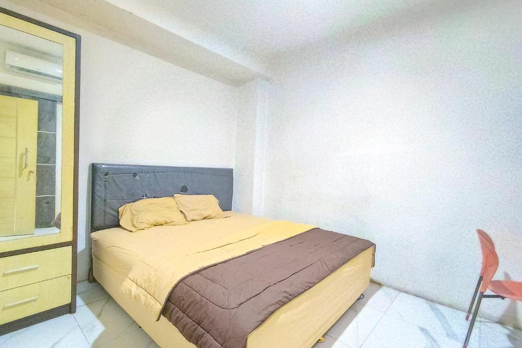 a bedroom with a bed and a chair in it at Guest House 88 RedPartner in Jakarta