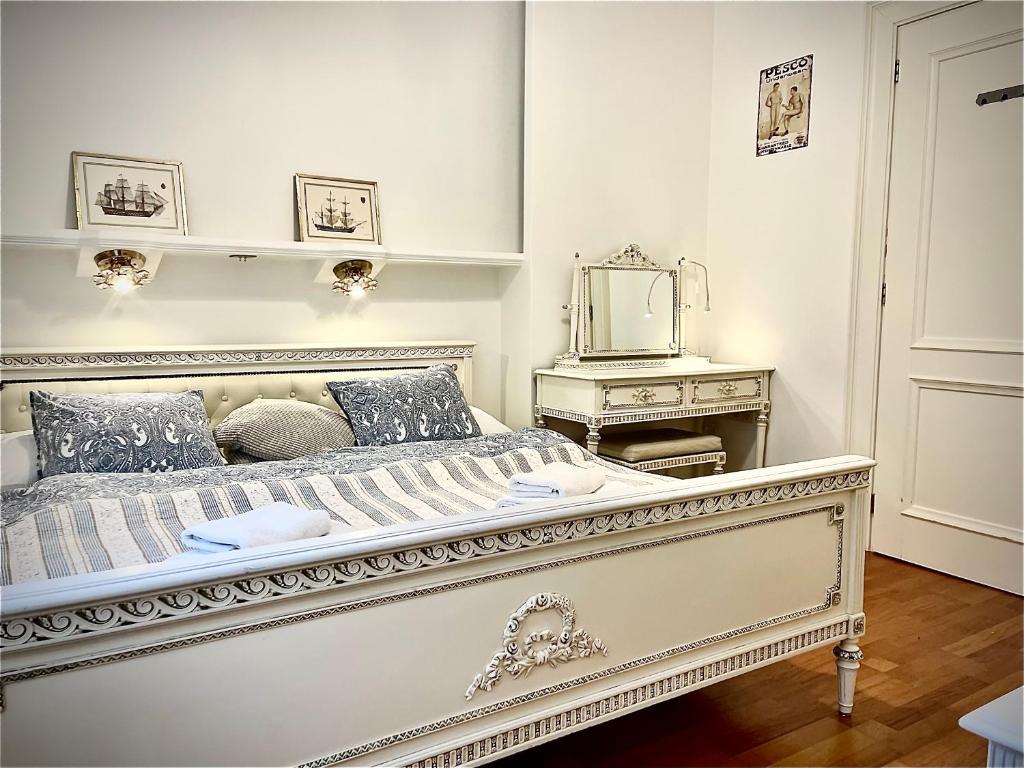 a white bedroom with a large bed and a mirror at Kwatera Prywatna Maja in Sopot