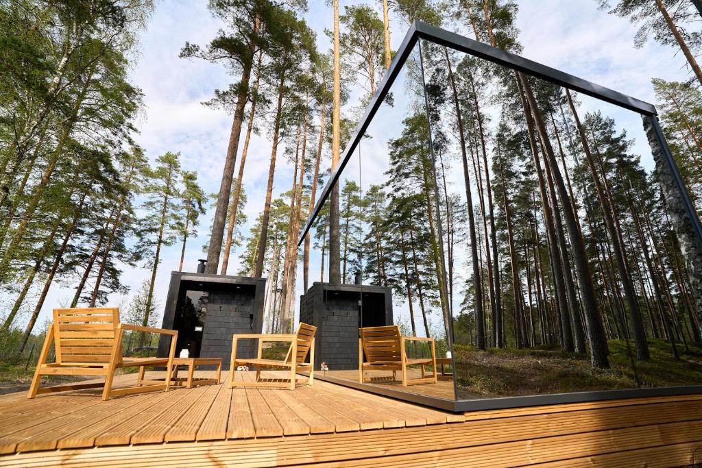 a group of chairs sitting on a deck with trees at Bejas Lux Mirror Houses 