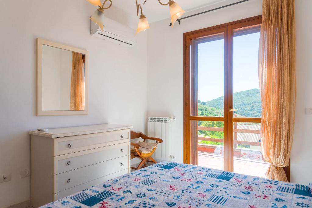 里奥内莱尔巴Appartamento Trilocale Cerboli的带床、梳妆台和窗户的卧室