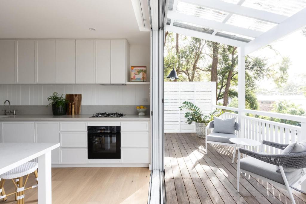 a kitchen with white cabinets and a table and chairs at Yachtsmans Paradise Retreat in Newport