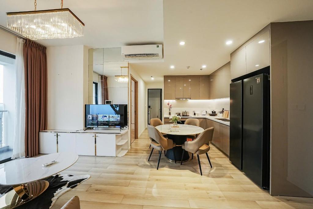 a kitchen and living room with a table and chairs at Bống Homestay-Luxury Apartment-Vinhomes Grand Park Quận 9 in Gò Công