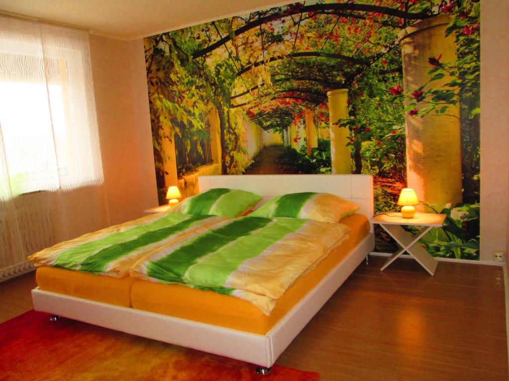 Schlafzimmer mit einem Bett mit Wandgemälde in der Unterkunft Ferienhaus am Geiersberg in Walkenried