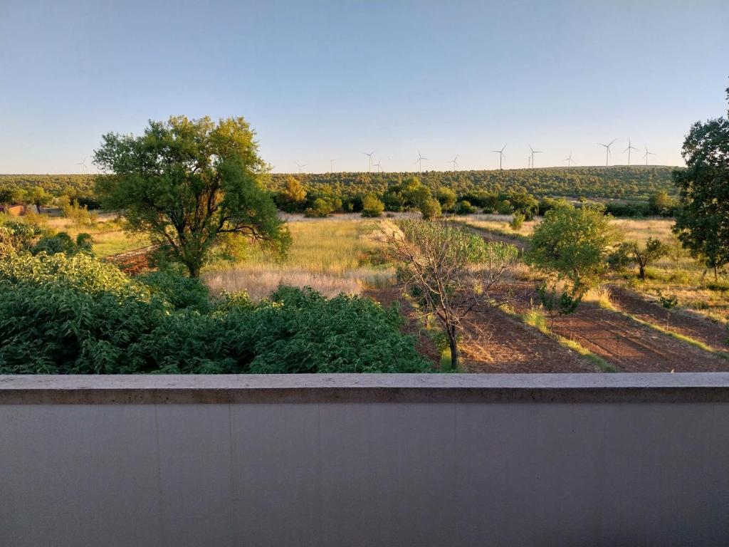a fence in front of a field with trees at Studio apartman u ruralnom okruženju in Donji Karin