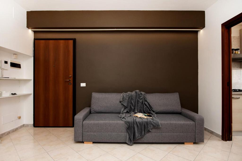 a couch with a blanket on it in a living room at Appartamento Le Palme in Tivoli Terme