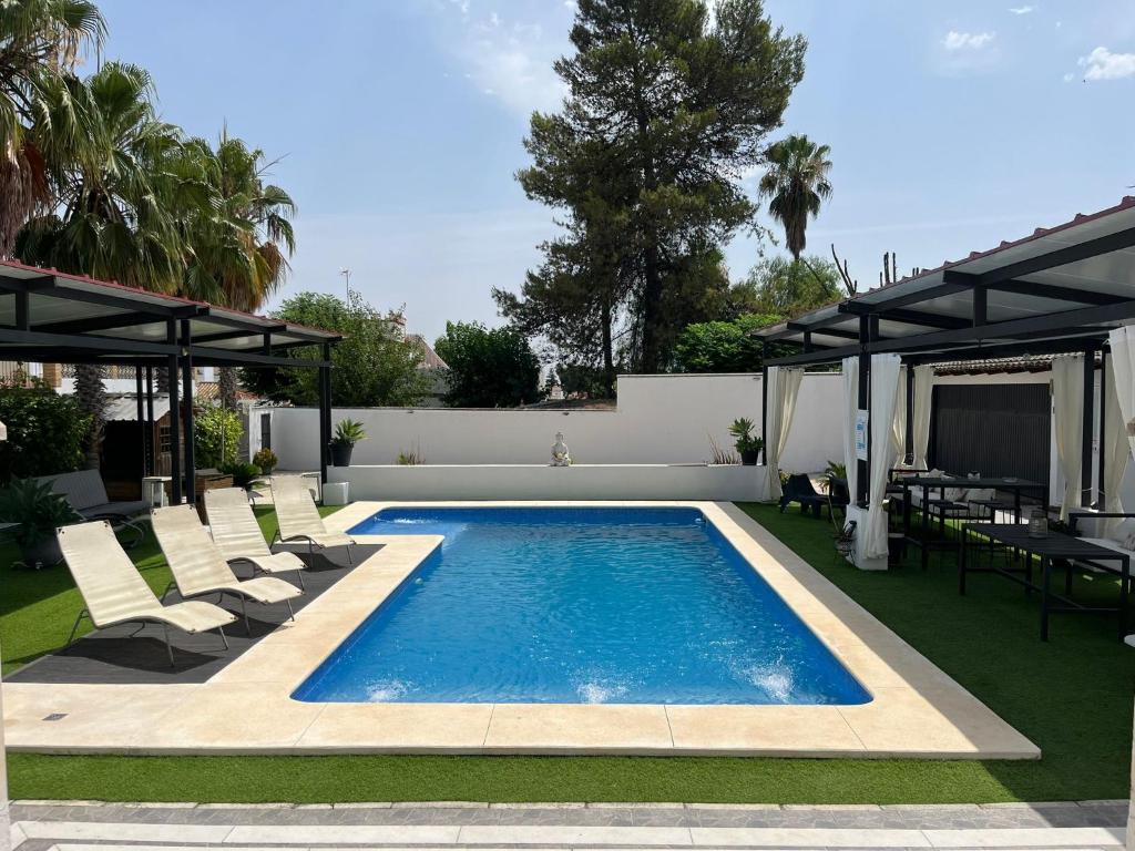 basen na dziedzińcu z krzesłami i patio w obiekcie Apartamento 2, Chalet Manzano a 15" de Sevilla, a 30" del Aeropuerto de Sevilla w mieście Villanueva del Ariscal