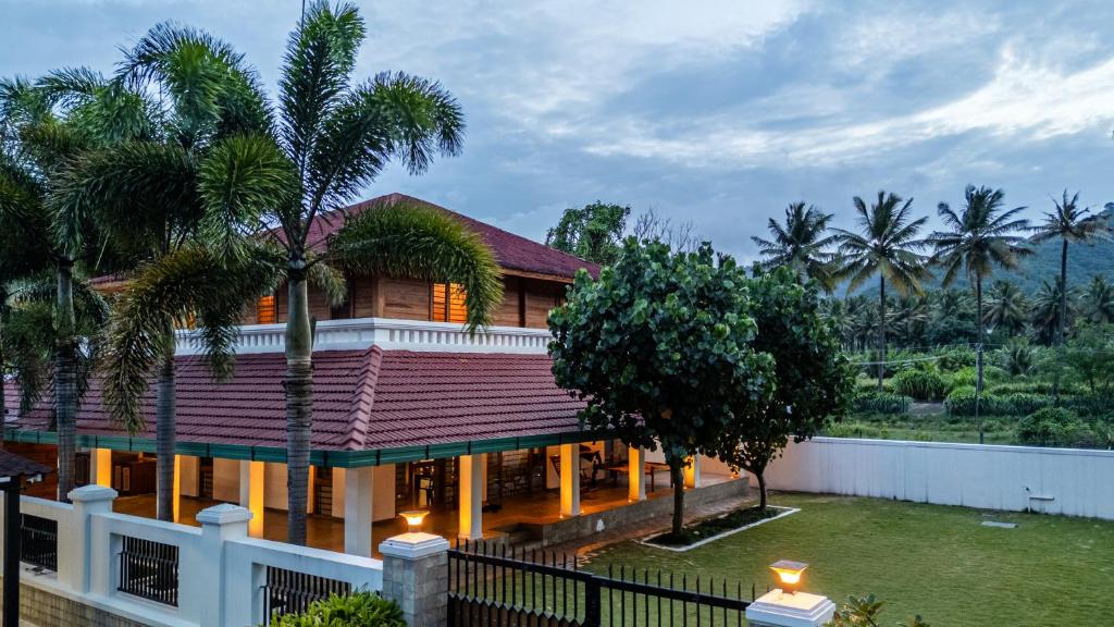 an image of a house with palm trees at Senaro Farms in Varagampadi