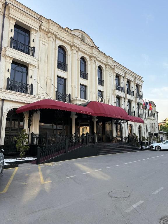 a large building with a red awning on a street at FRANKFORT Expo Hotel in Tashkent