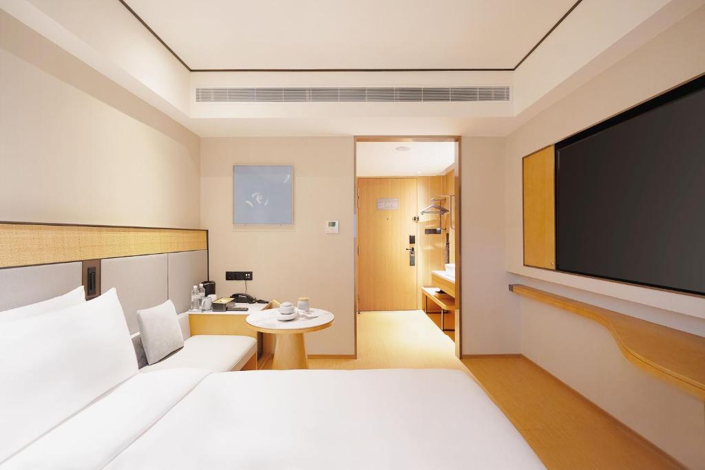 a hotel room with a flat screen tv at Ji Hotel Orchard Singapore in Singapore