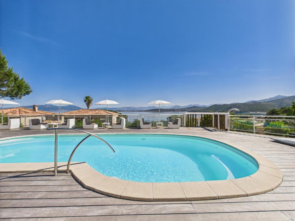 a swimming pool on a deck with a view of the water at Résidence Aigue Marine in Coti-Chiavari