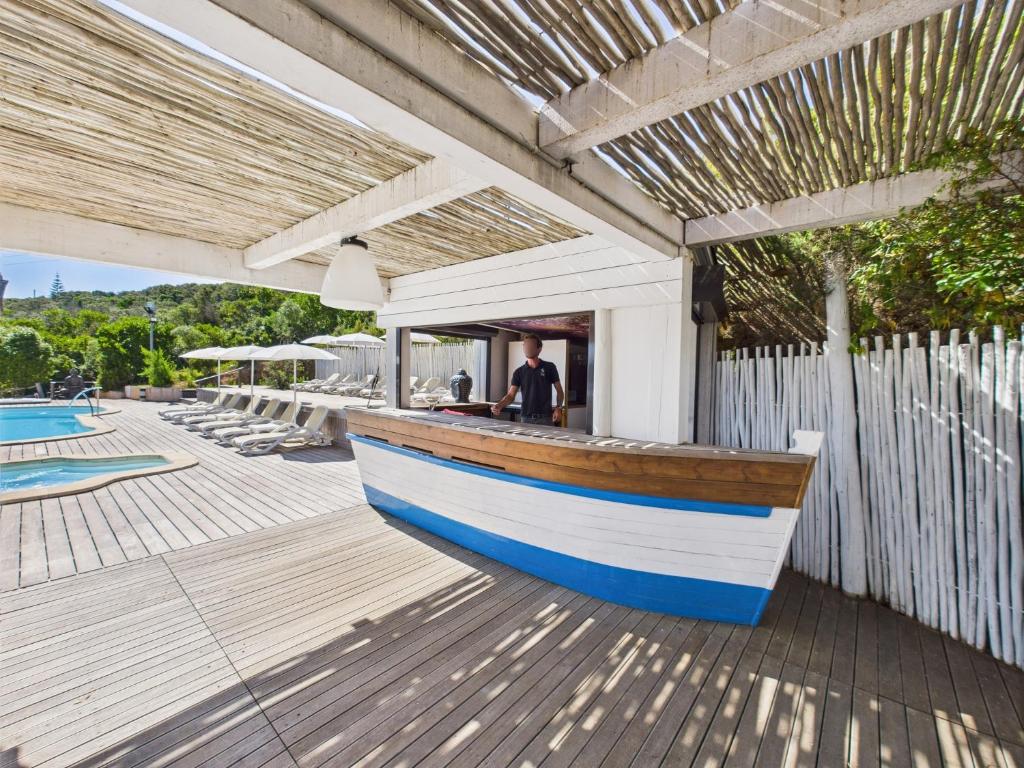 a wooden boat sitting on a deck next to a fence at Résidence Aigue Marine in Coti-Chiavari
