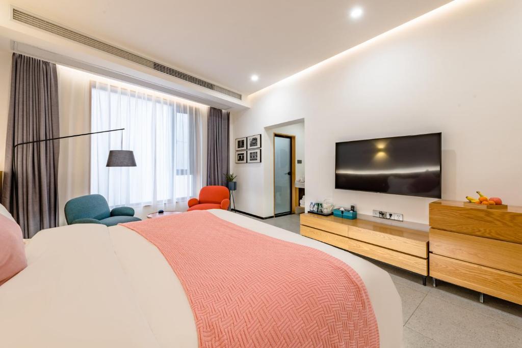 een hotelkamer met een groot bed en een flatscreen-tv bij Zhangjiajie Tianmen Mountain Cableway High-end B&B in Zhangjiajie