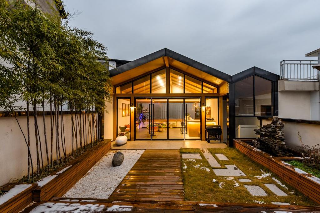 een huis met glazen deuren en een houten terras bij Zhangjiajie Tianmen Mountain Cableway High-end B&B in Zhangjiajie
