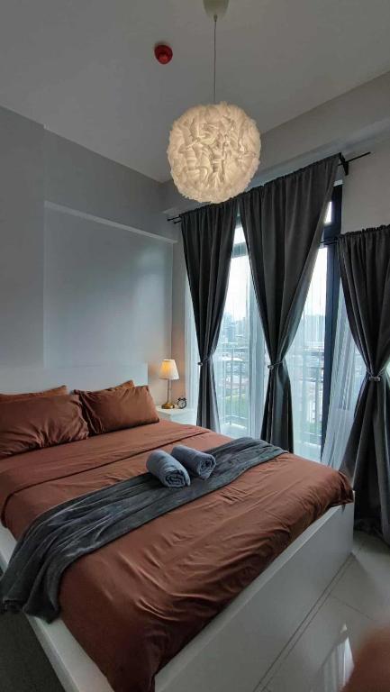 a bedroom with a large bed and a large window at The Hmlet Manila, Near Poblacion Makati Nightlife in Manila